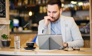 stock-photo-successful-young-businessman-using-a-tablet-while-working-in-a-modern-coffee-shop-work-anywhere-1053471215
